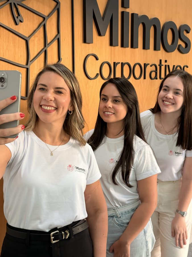 CEO e equipe da Mimos Corporativos em frente ao letreiro da marca